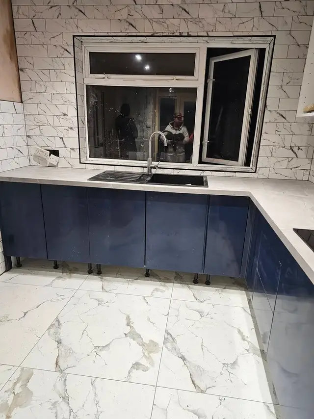 Marble-effect kitchen floor tiles with white textured wall tiles